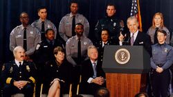 Photo of Senator Biden giving a speech, with uniformed law enforcement officers in the background
